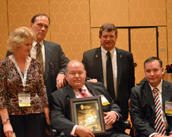 Jere White (center) with his wife Linda and son Robert, honored by NCGA CEO Rick Tolman and president Martin Barbre