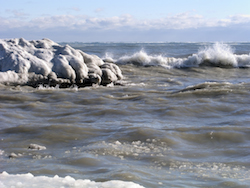 Ocean waves crash along an icy winter shoreline Photo @Redking